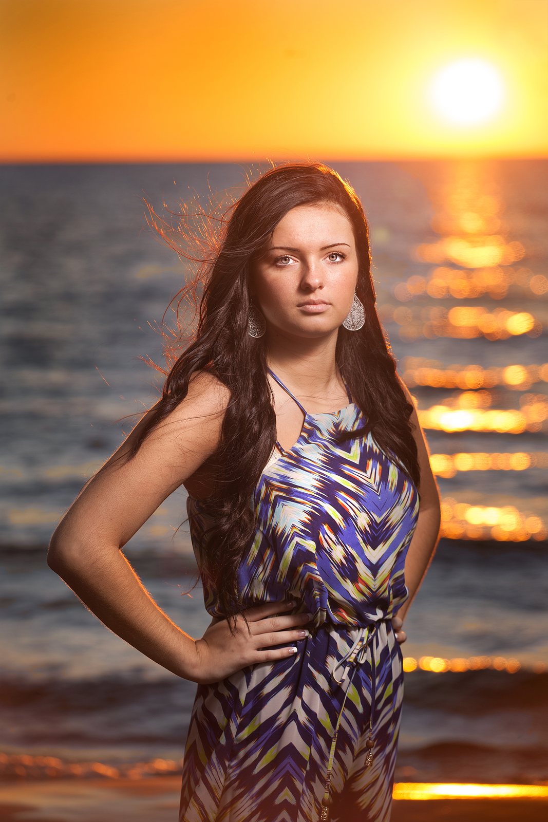 Senior portrait of a young woman by the lake at golden hour