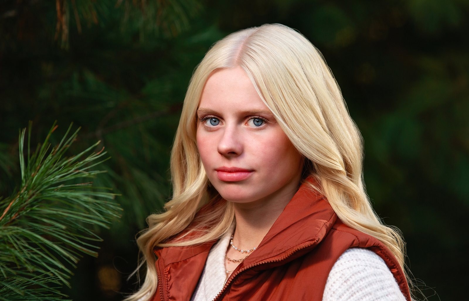Senior portrait of a young woman in a rust vest