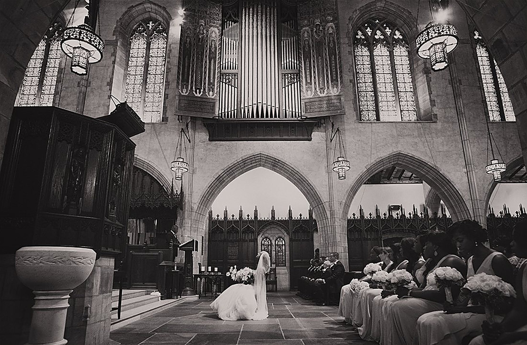 Bride entering a grand cathedral for the ceremony, in black and white